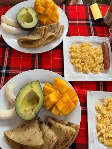 a table with three plates of food with fruit on it at Patience Airport cottages in Boma la Ngombe