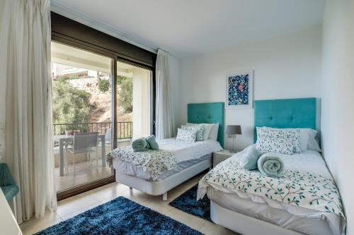 a bedroom with two beds and a balcony at Samara Resort Gym Spa Jacuzzi Pools in Marbella in Marbella