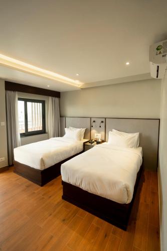 a hotel room with two beds and a window at ila comfort in Bāglung