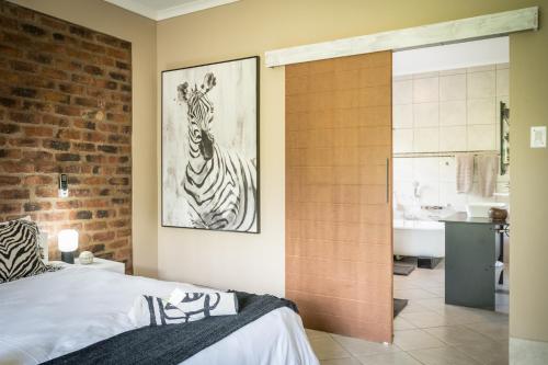 a bedroom with a zebra picture on the wall at Bosveld Villa in Marloth Park