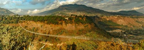 a bridge on the side of a mountain at ila comfort in Bāglung
