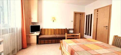 a hotel room with a bed and a couch at Garni B&B Apartments Plank in Nova Levante