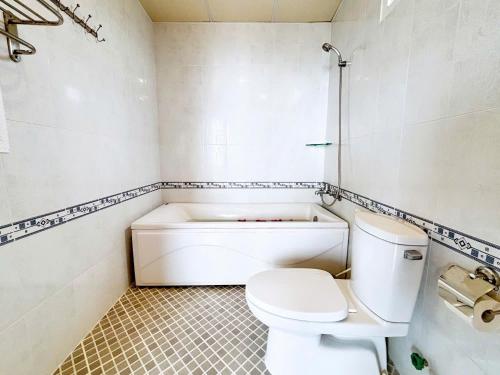 a bathroom with a toilet and a bath tub at Ha Phuong Mui Ne Hotel in Mui Ne