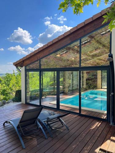 - une vue sur une terrasse avec une chaise et une piscine dans l'établissement Maison Réauville, à Réauville