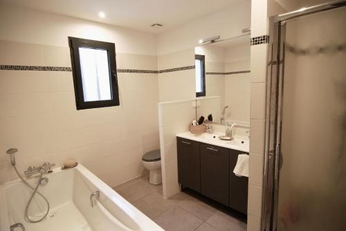 une salle de bain avec une baignoire, des toilettes et un lavabo dans l'établissement Maison Réauville, à Réauville