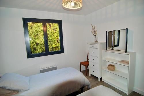 - une chambre avec un lit, un miroir et une commode dans l'établissement Maison Réauville, à Réauville