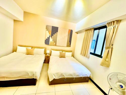 a bedroom with two beds and a window at 莫蘭狄 in Taichung