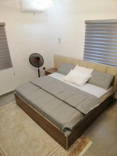 a large bed in a room with a fan at Private Room 5G Wifi Work Desk Fridge in Sangotedo