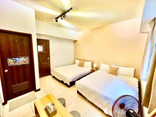 a hotel room with two beds and a fan at 莫蘭狄 in Taichung