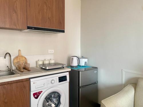 a kitchen with a washing machine and a sink at Affordable Staycation near Airport and beach in Suba