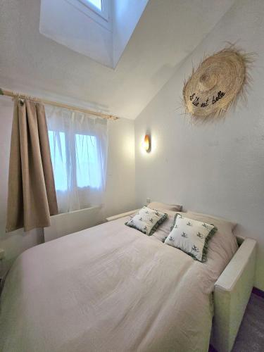 une chambre avec un grand lit blanc avec deux oreillers dans l'établissement Le duplex, à Bussy-Saint-Georges