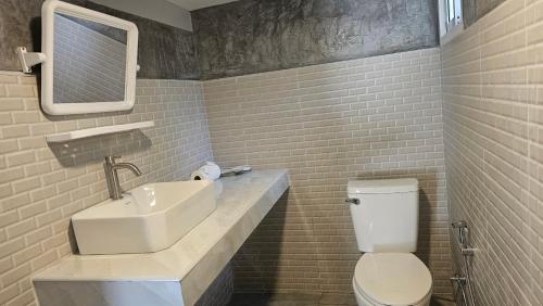 a bathroom with a sink and a toilet and a mirror at Classic home in Bang Tao Beach