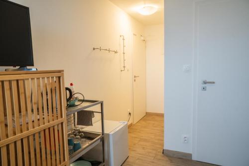 a living room with a television and a white wall at Varalja Apartments in Plavecké Podhradie