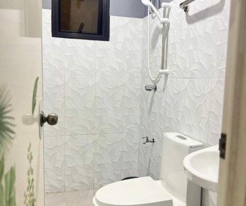 Un baño con ducha, inodoro y lavabo. en P3k suites barkada family room, en Manila