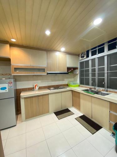 a large kitchen with wooden cabinets and stainless steel appliances at Wanie CH Homestay 1 Brinchang Cameron Highlands in Brinchang