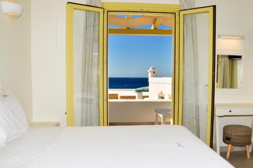 a bedroom with a bed and a view of the ocean at Sohoro in Koufonisia