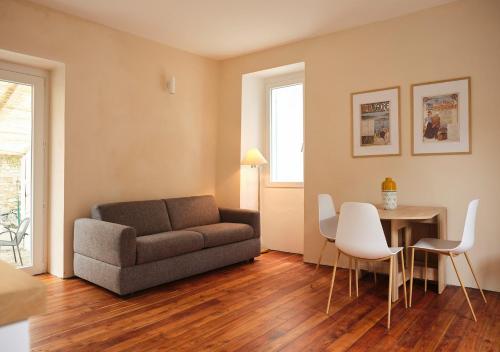 a living room with a couch and a table and chairs at Appartamento BACCO in Feriolo