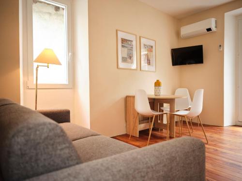 a living room with a couch and a table and chairs at Appartamento BACCO in Feriolo