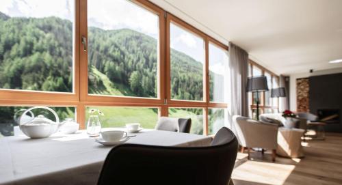 a dining room with a table and a large window at Wanderhotel Talblick in San Giacomo
