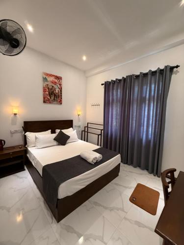 a bedroom with a large bed with a black curtain at Devon Surf . Inn - Hiriketiya in Dickwella