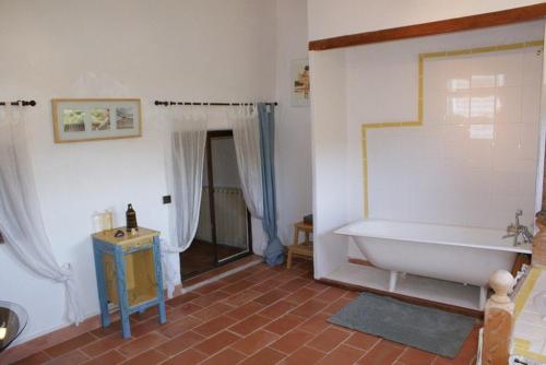 La salle de bains est pourvue d'une baignoire blanche et de carrelage rouge. dans l'établissement Accommodation in a farmhouse with breathtaking views, à Brignoles