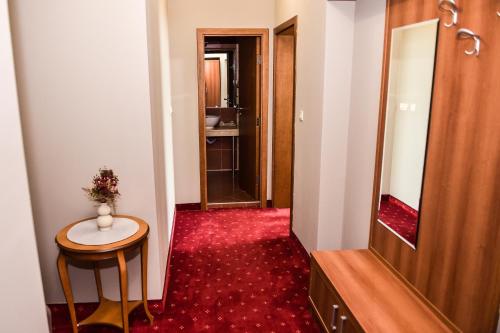 a hallway with a small table and a mirror at Хотел "Скалите", Skalite Hotel in Belogradchik