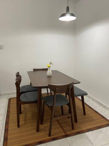 バンティングにあるHomestay Idaman, Olak Lempit at Bantingの木製テーブル(椅子2脚付)と花瓶