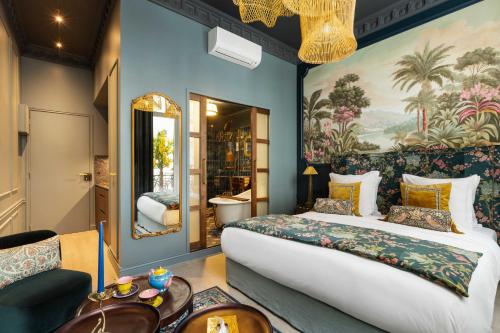 une chambre avec un grand lit et un tableau au mur dans l'établissement The Grand Champs Elysées, à Paris