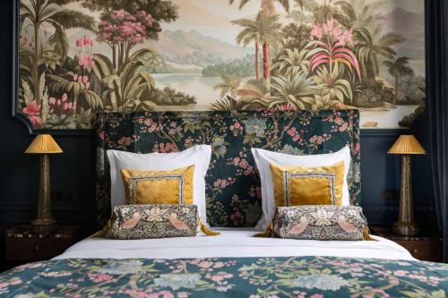 une chambre avec un lit avec un papier peint fleuri dans l'établissement The Grand Champs Elysées, à Paris