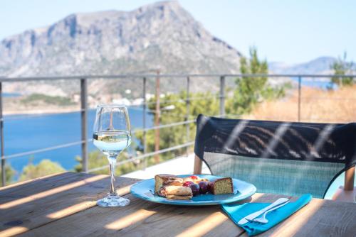 a plate of food and a glass of wine on a table at Gestema Luxury Residences in Kalymnos