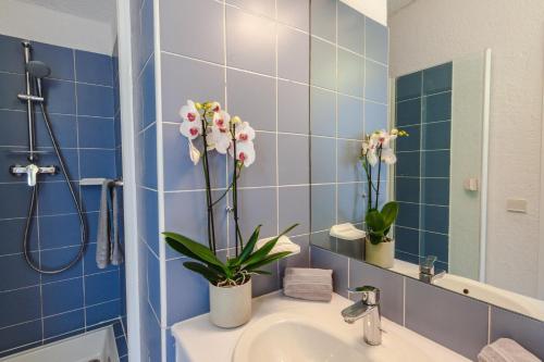 a bathroom with a sink with flowers on the counter at CAPSUD, La Garde-Freinet in La Garde-Freinet