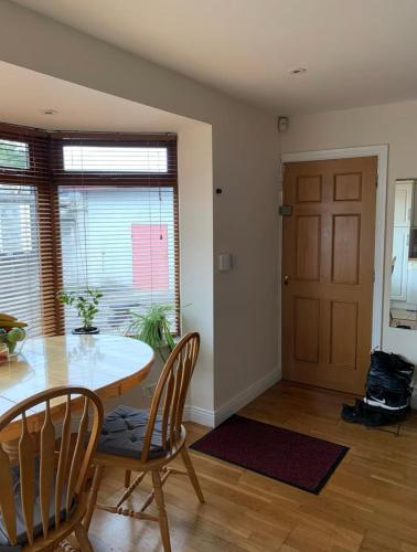 a dining room with a table and chairs and a door at lovely bedroom in Newbridge in Newbridge