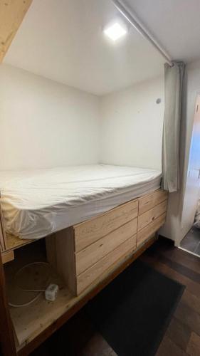 Ce lit se trouve dans un dortoir doté d'un cadre de lit en bois. dans l'établissement Résidence Roche Mantel - APPARTEMENT ALPE D'HUEZ 27m2 ECLOSE EST MAE-0541, à Huez