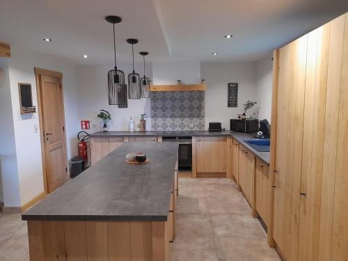 a kitchen with wooden cabinets and a large counter top at Le refuge de Julia in La Roche-en-Ardenne