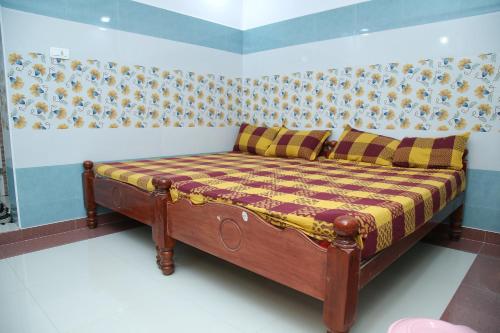 a small bed in a room with a wall at Ambika Residency & Mahal in Tiruttani