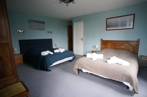 a bedroom with two beds and blue walls at Les Grandes Landes - Piscine privée - Grand jardin in Cricqueville-en-Bessin