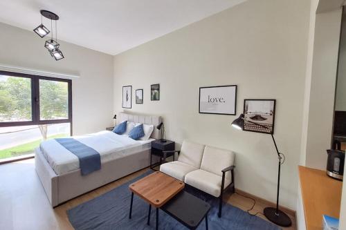 a bedroom with a bed and a chair and a table at Modern Renovated Studio Building 197 - 5 Min Walking from Metro and Pavilions in Dubai