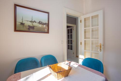 a dining room with a table and blue chairs at Montesan Luxury Apartment Beach Front in Sveti Stefan