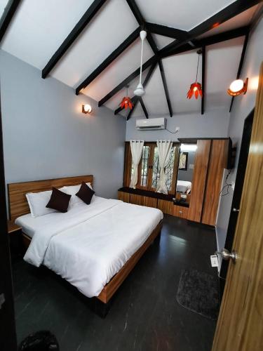 a bedroom with a large white bed in a room at Raghunandan Resort Cottages in Nashik