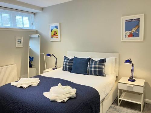 a bedroom with a bed with blue sheets and blue pillows at Park Mews Glasgow in Glasgow
