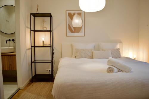 a bedroom with a large white bed and a bathroom at Luxury room with private bathroom on great location. in Amsterdam