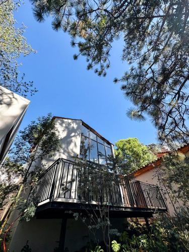 a balcony on the side of a building with trees at Serenzzo Hotel & Cuisine in Tapalpa