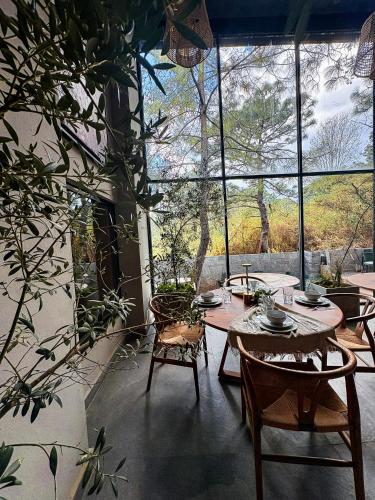 a table and chairs in a room with a large window at Serenzzo Hotel & Cuisine in Tapalpa