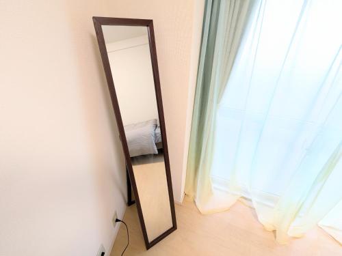 a mirror on a wall next to a window at Chateau Sunrise in Tokyo