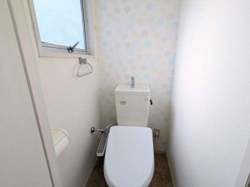 a bathroom with a white toilet with a window at Chateau Sunrise in Tokyo