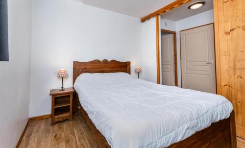 une chambre avec un grand lit avec une tête de lit en bois dans l'établissement Résidence Les Hauts De Preclaux - Appartement avec deux chambres aux Orres 1800 MAE-0161, aux Orres