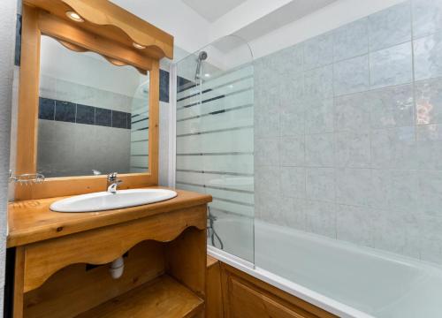 une salle de bain avec un lavabo, une baignoire et un miroir dans l'établissement Résidence Les Hauts De Preclaux - Appartement avec deux chambres aux Orres 1800 MAE-0161, aux Orres