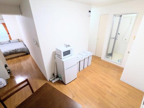 a small white room with a microwave on a table at Chateau Sunrise in Tokyo