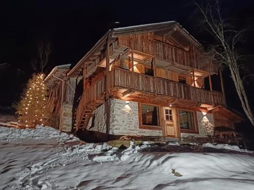a log cabin in the snow with a christmas tree at Baita Mas al Rif in Rabbi