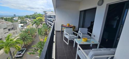 a balcony with chairs and a table and a street at L'appartement de l'Horizon - Plateau Cailloux in Fleurimont